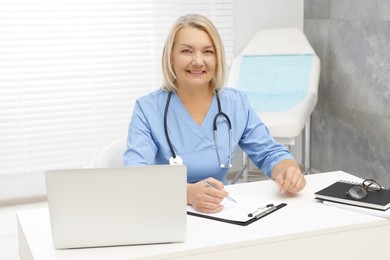 Photo of Doctor working at white table in clinic