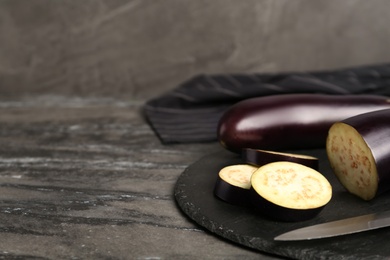 Photo of Fresh eggplants on grey table, closeup. Space for text