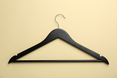 Black hanger on pale yellow background, top view