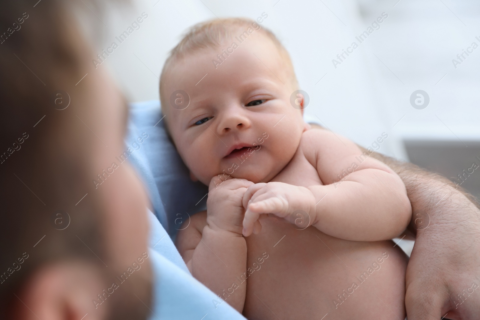 Photo of Father holding his cute newborn baby at home, closeup