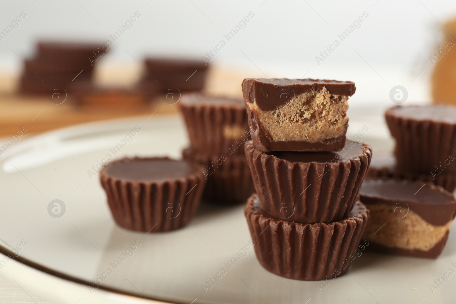 Photo of Cut and whole delicious peanut butter cups on plate, space for text