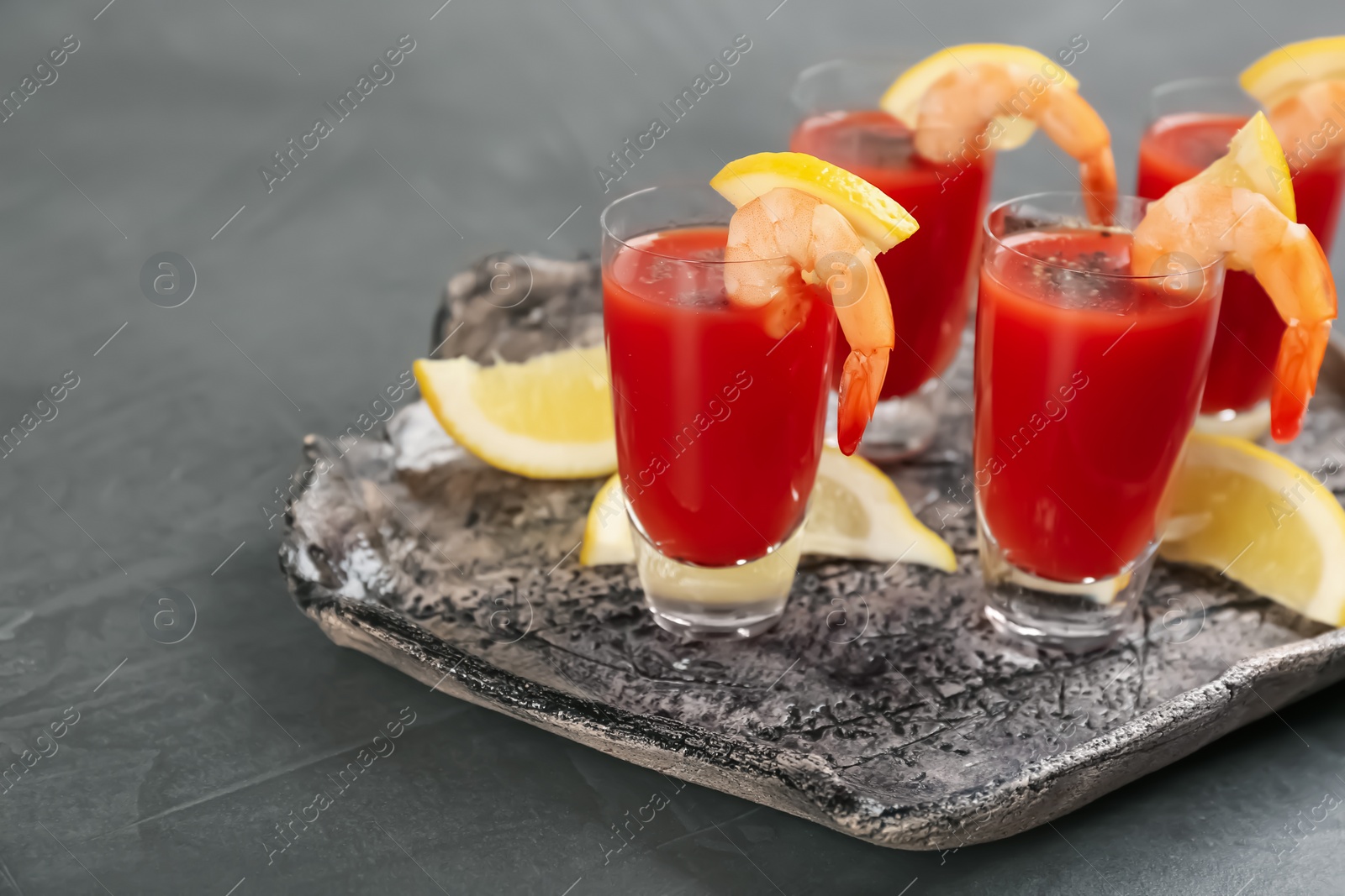 Photo of Delicious shrimp cocktail with tomato sauce on grey table