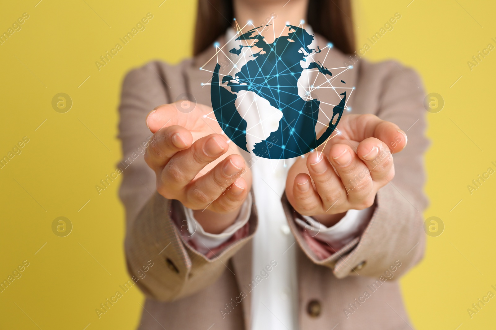 Image of Global network technology. Woman demonstrating planet with connection lines on yellow background, closeup