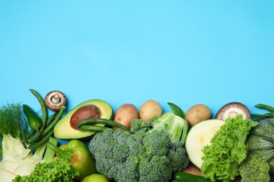 Photo of Flat lay composition with fresh vegetables on light blue background. Space for text
