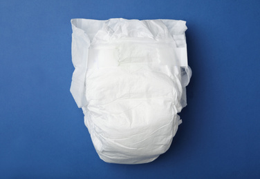 Photo of Baby diaper on blue background, top view