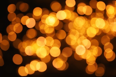 Photo of Gold glitter with bokeh effect on dark background