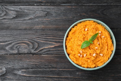 Bowl with mashed sweet potatoes on wooden table, top view. Space for text