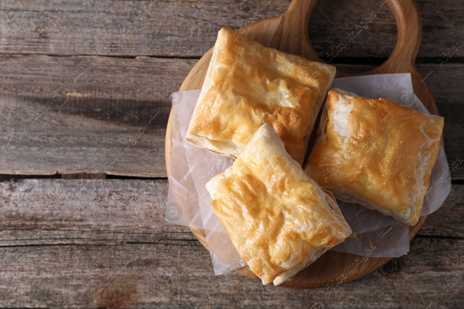 Photo of Delicious puff pastry on wooden table, top view. Space for text