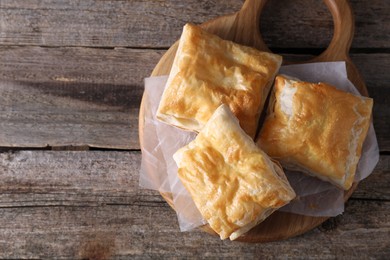 Delicious puff pastry on wooden table, top view. Space for text