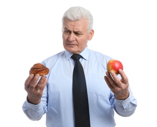 Photo of Senior man with pastry and apple on white background. Diabetes diet