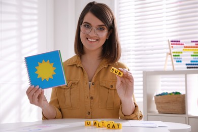 Happy female English teacher giving lesson indoors. Early childhood education