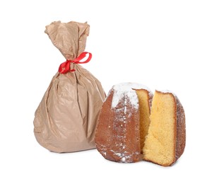 Photo of Delicious Pandoro cake decorated with powdered sugar and paper bag isolated on white. Traditional Italian pastry