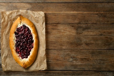 Delicious sweet cottage cheese pastry with cherry jam on wooden table, top view. Space for text