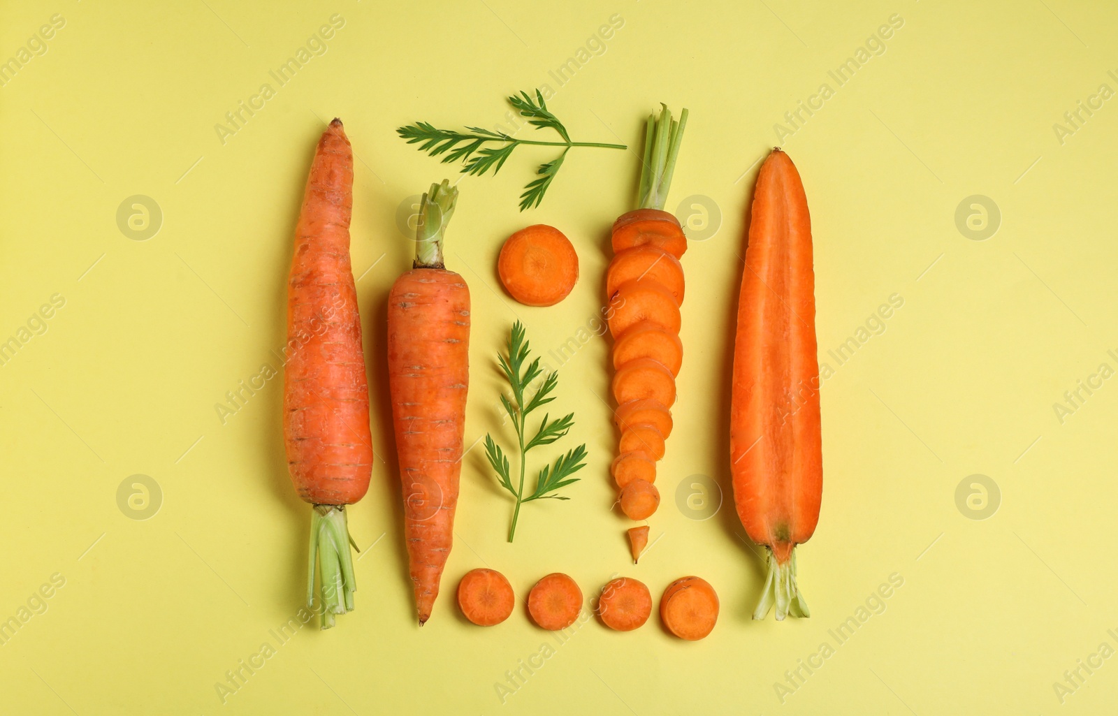 Photo of Creative flat lay composition with fresh ripe carrots on color background