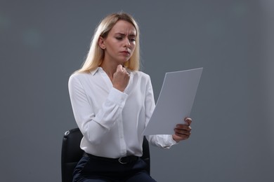 Photo of Casting call. Emotional woman with script performing against grey background