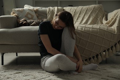 Photo of Sad young woman and her dog at home