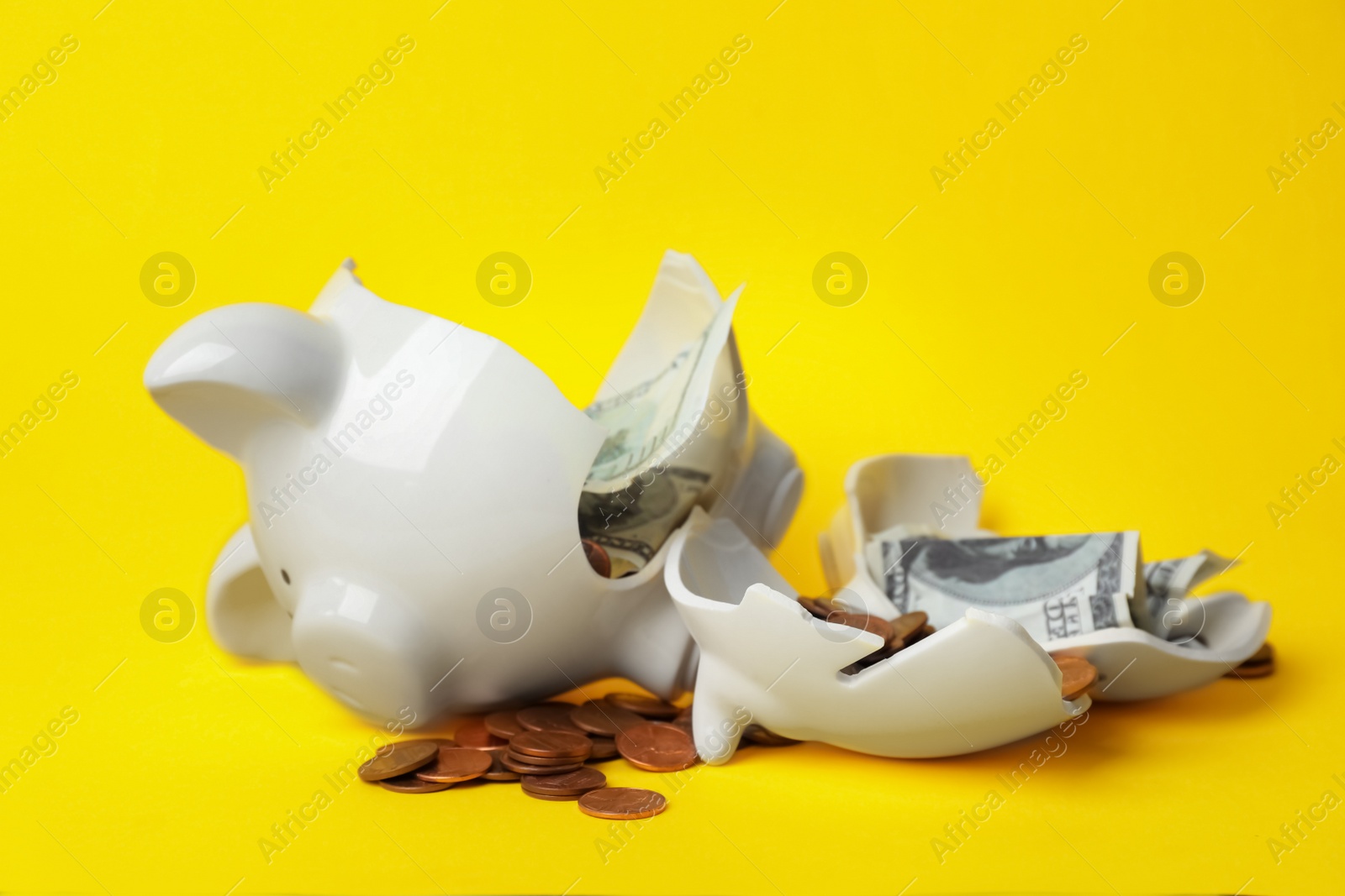 Photo of Broken piggy bank with coins and banknotes on color background