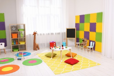 Photo of Child`s playroom with different toys and furniture. Cozy kindergarten interior