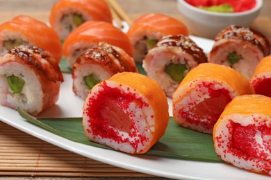 Different delicious sushi rolls on white plate, closeup