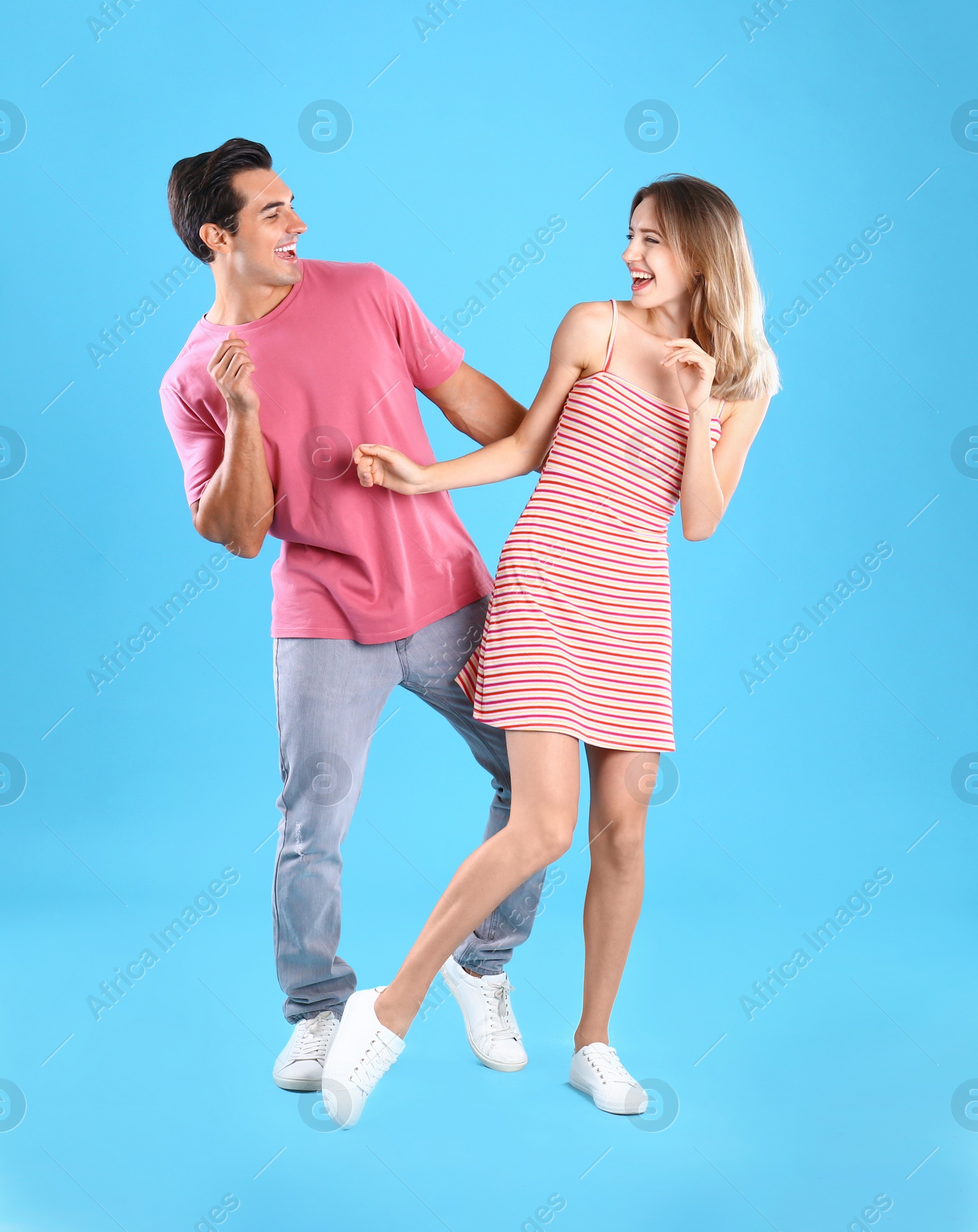 Photo of Beautiful young couple dancing on blue background