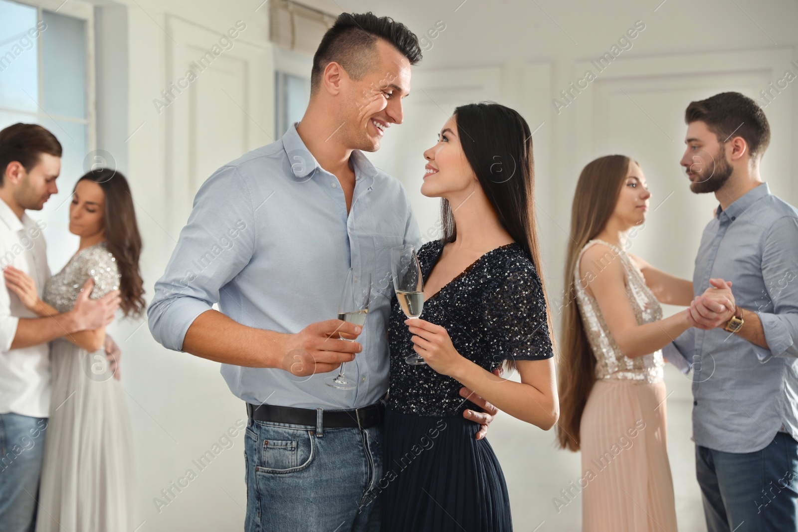 Photo of Lovely young couple with glasses of champagne at dancing party