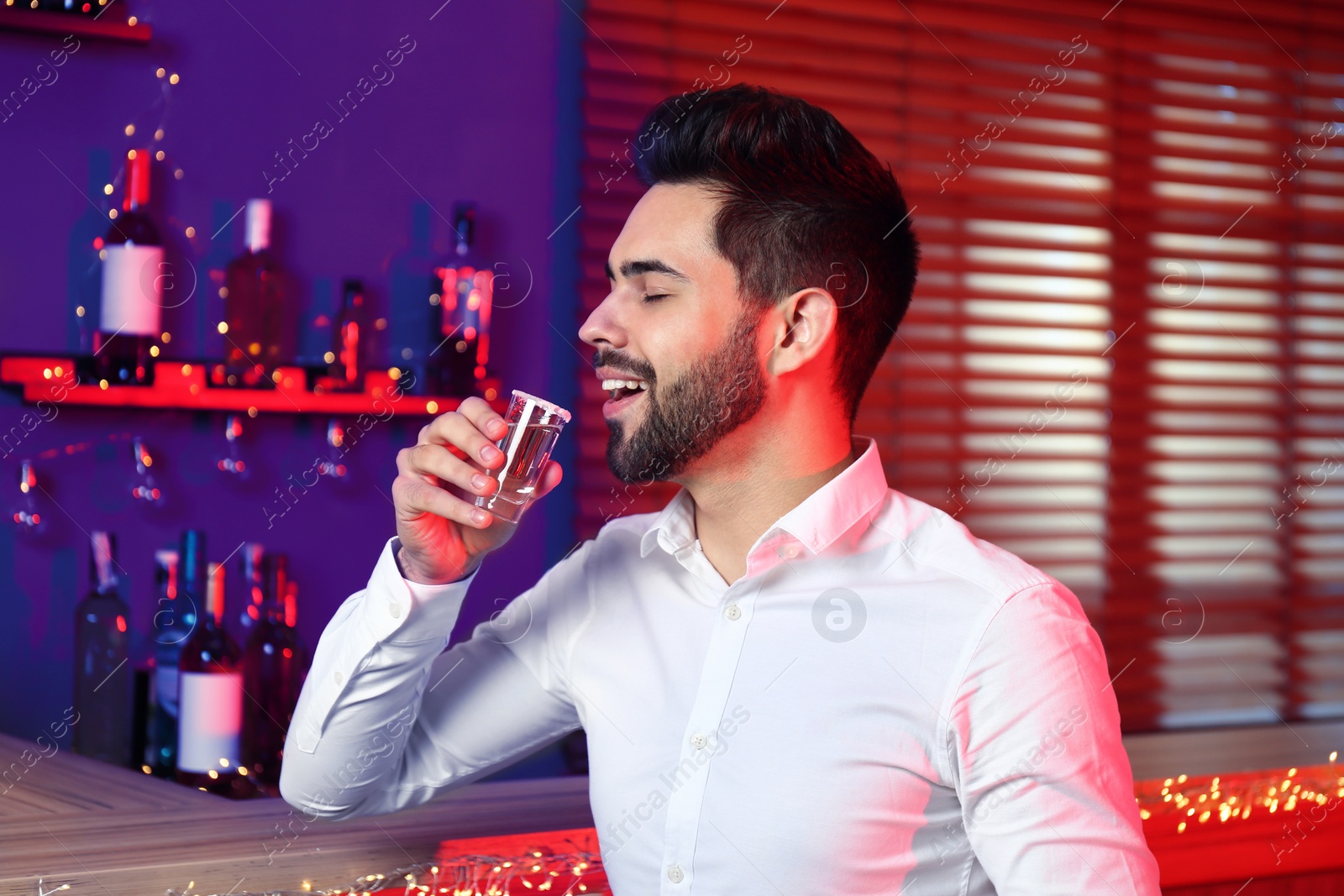 Photo of Young man with Mexican Tequila shot in bar