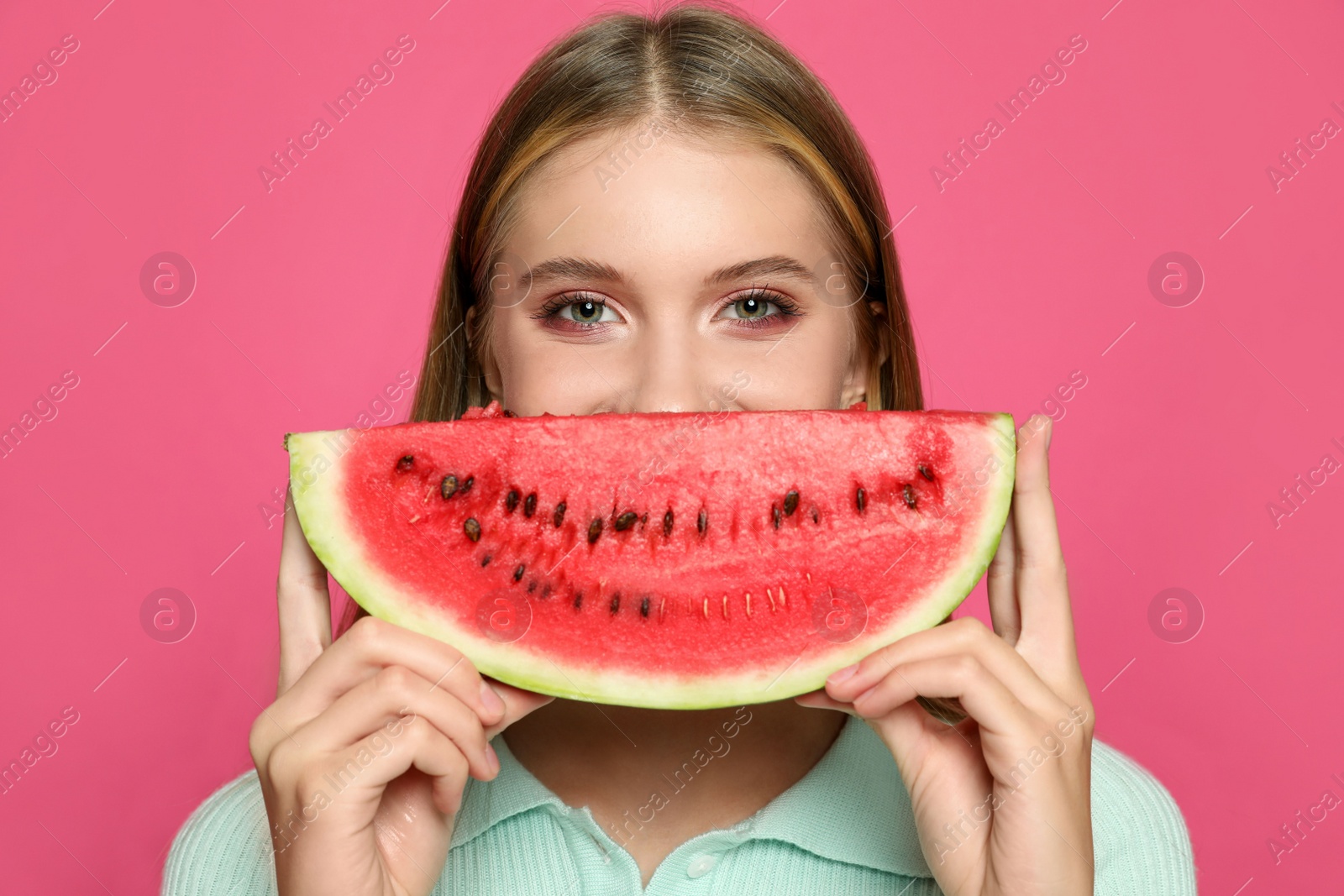 Photo of Beautiful girl with slice of watermelon on crimson background