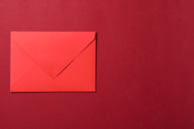 Photo of Letter envelope on red background, top view. Space for text