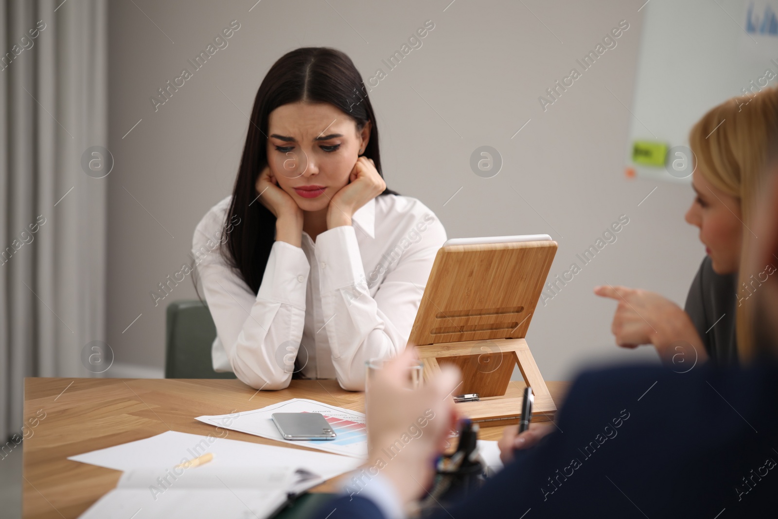 Photo of Coworkers bullying their colleague at workplace in office,