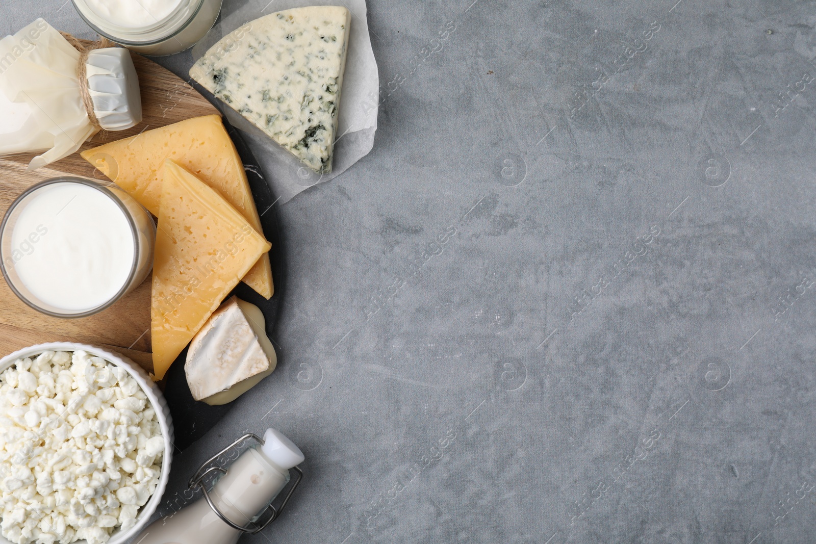 Photo of Different fresh dairy products on grey table, top view. Space for text