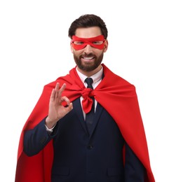 Photo of Happy businessman in red superhero cape and mask showing ok gesture on white background