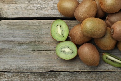 Photo of Pile of fresh ripe kiwis on wooden table, flat lay. Space for text