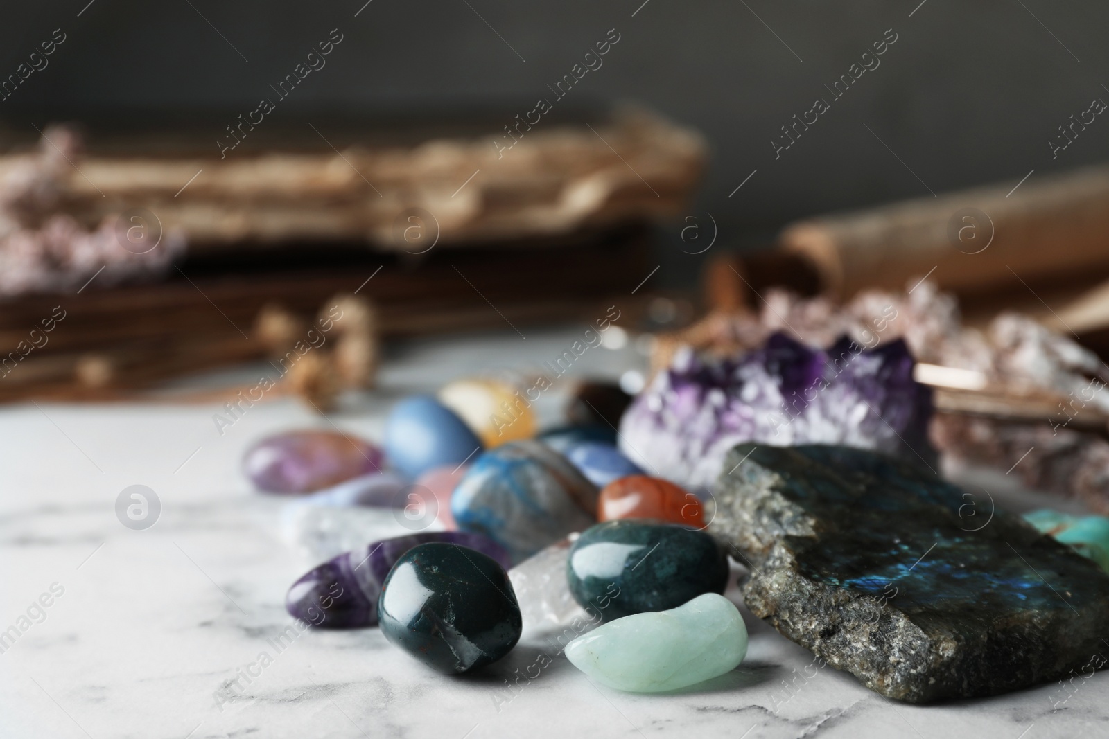 Photo of Pile of different beautiful gemstones on marble table
