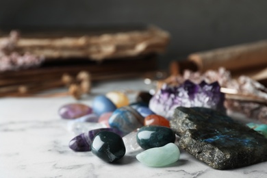 Pile of different beautiful gemstones on marble table