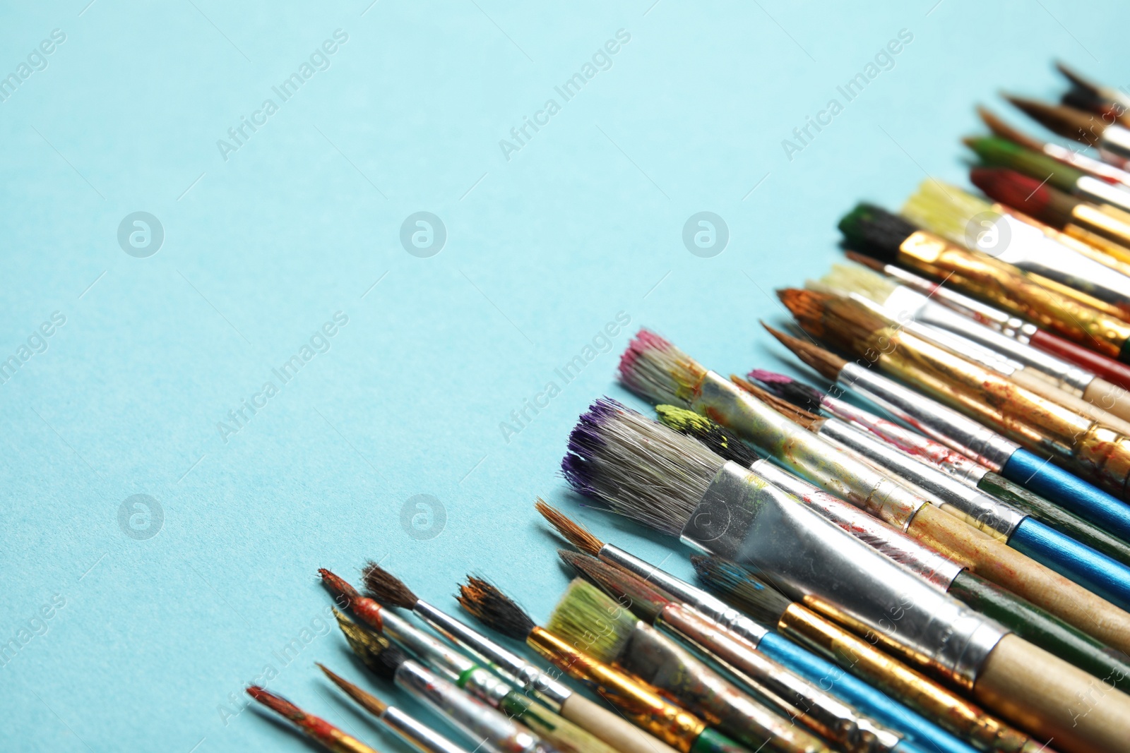 Photo of Different paint brushes on color background. Space for text