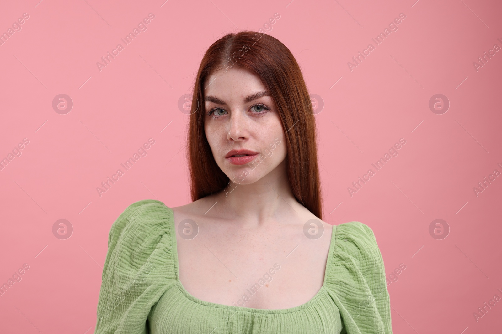 Photo of Portrait of beautiful woman with freckles on pink background