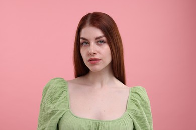 Portrait of beautiful woman with freckles on pink background