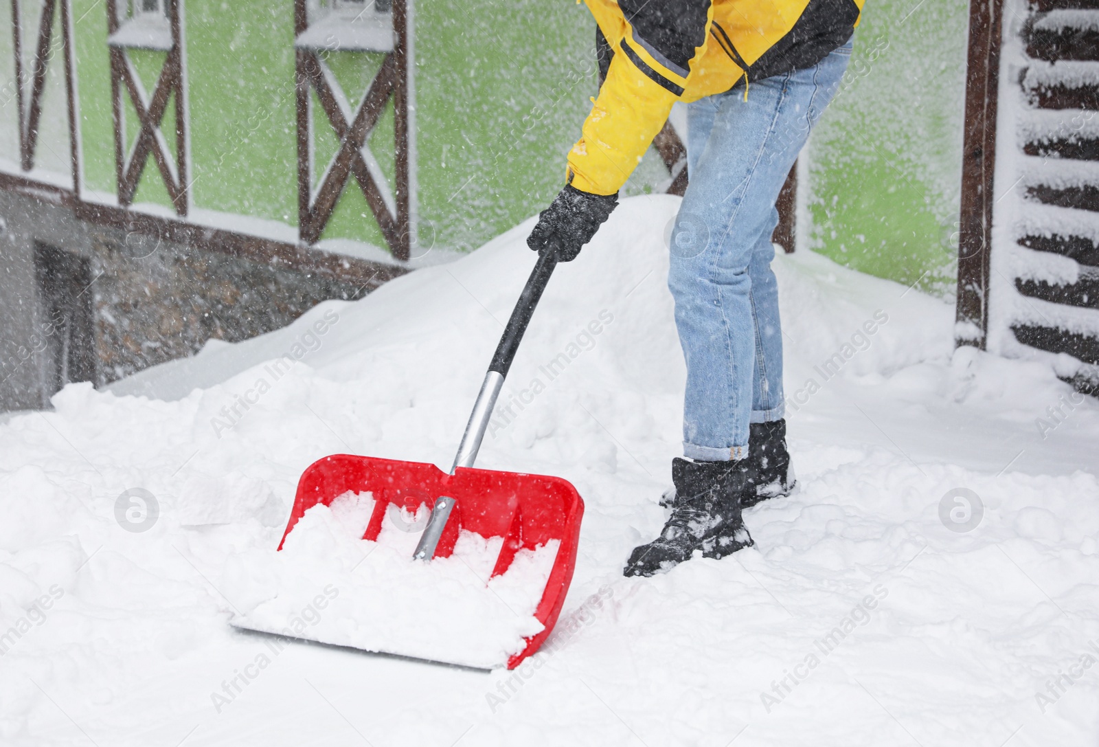 Photo of Man cleaning snow with shovel outdoors, closeup