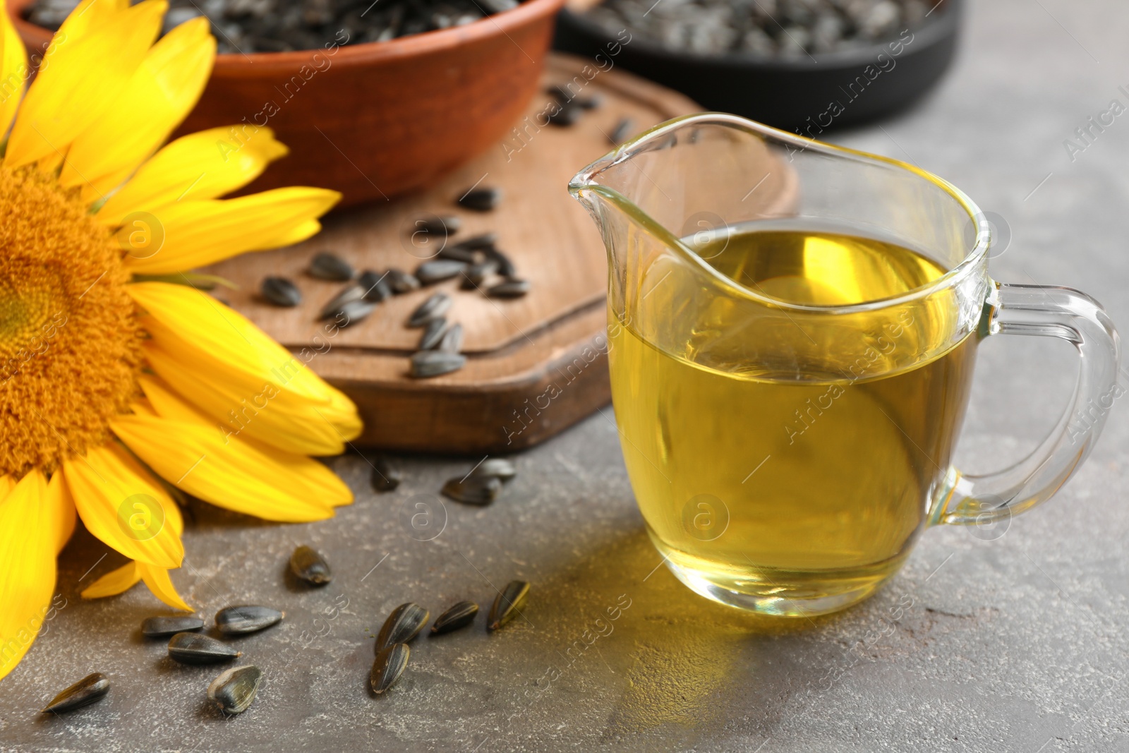 Photo of Jug with sunflower oil on table, closeup