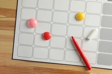 Photo of Timetable. Planner, felt pen and drawing pins on wooden table, top view