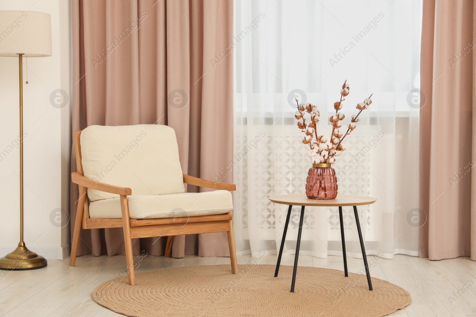 Photo of Living room with pastel window curtains, wooden table and armchair