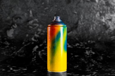 Photo of Used can of spray paint on black marble background