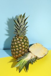 Photo of Whole and cut ripe pineapples on color background