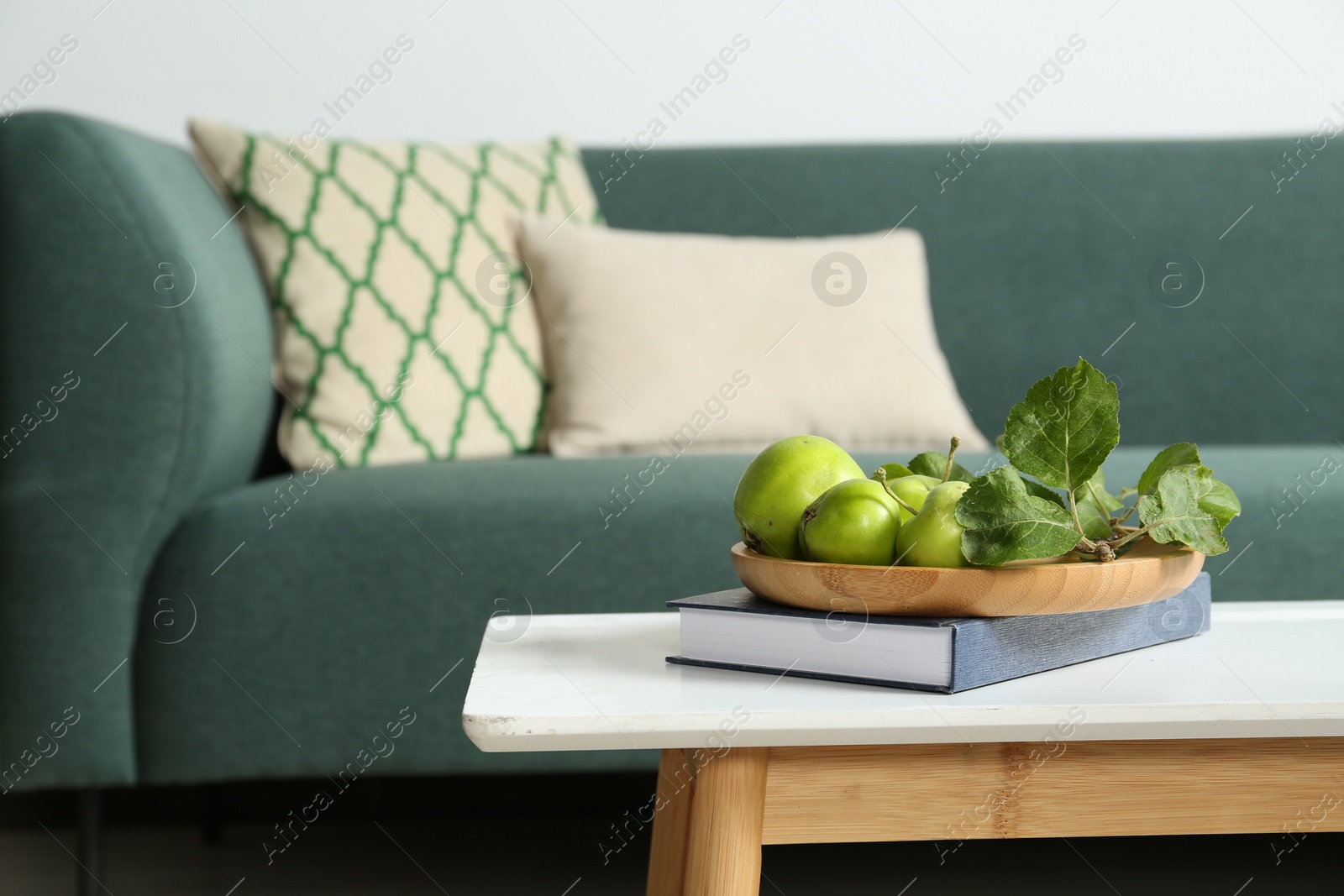 Photo of Fresh green apples on white wooden table in living room, space for text