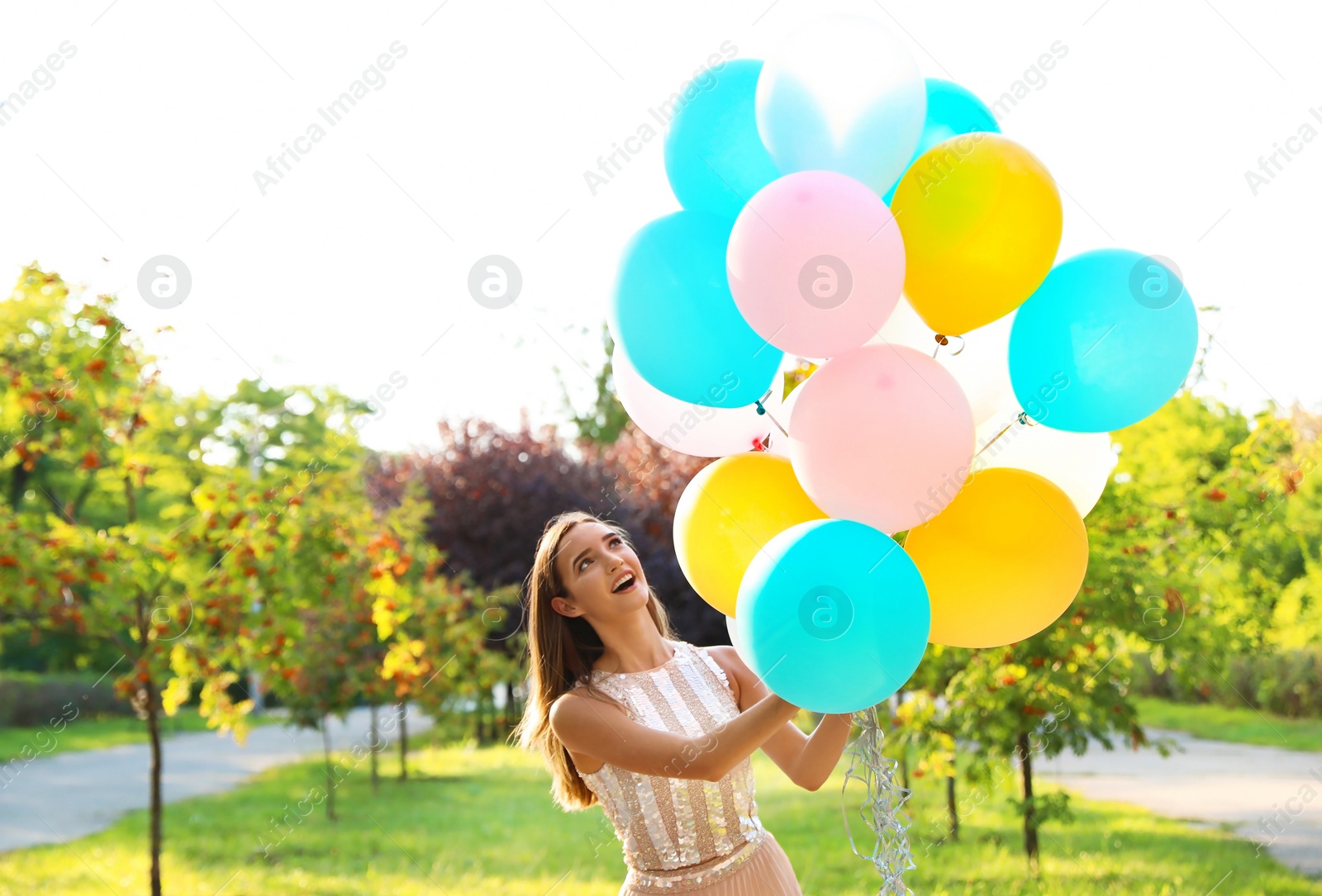 Photo of Beautiful teenage girl holding colorful balloons in park