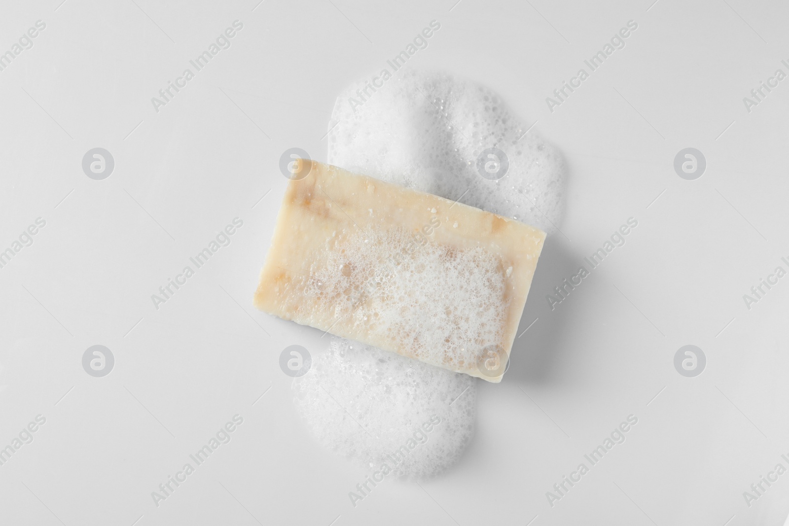 Photo of Soap with fluffy foam on white background, top view