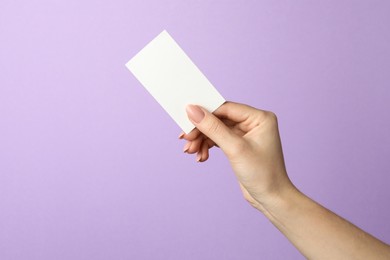 Photo of Woman holding blank business card on violet background, closeup. Mockup for design
