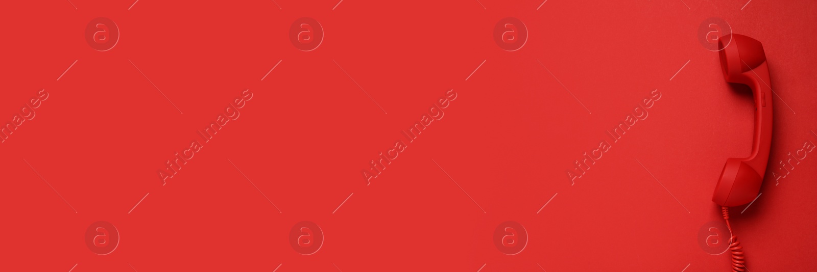 Image of Hotline service. Red telephone receiver and space for text on red background, top view