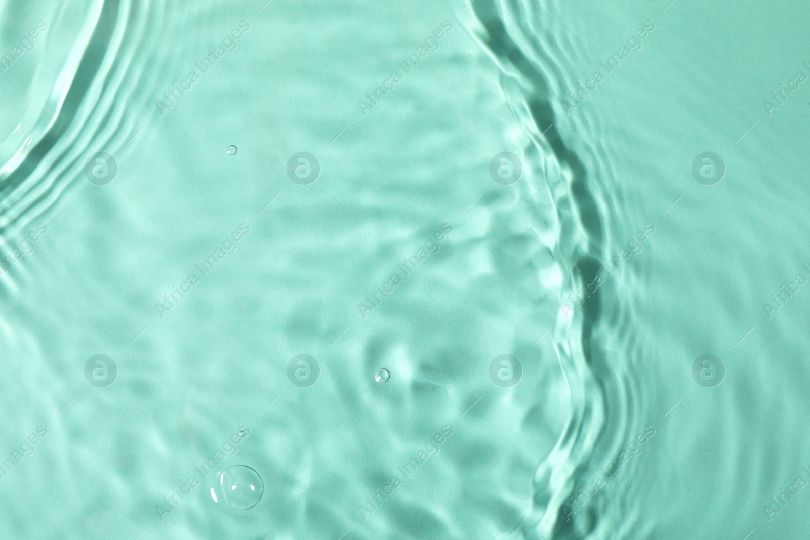 Photo of Closeup view of water with rippled surface on light blue background