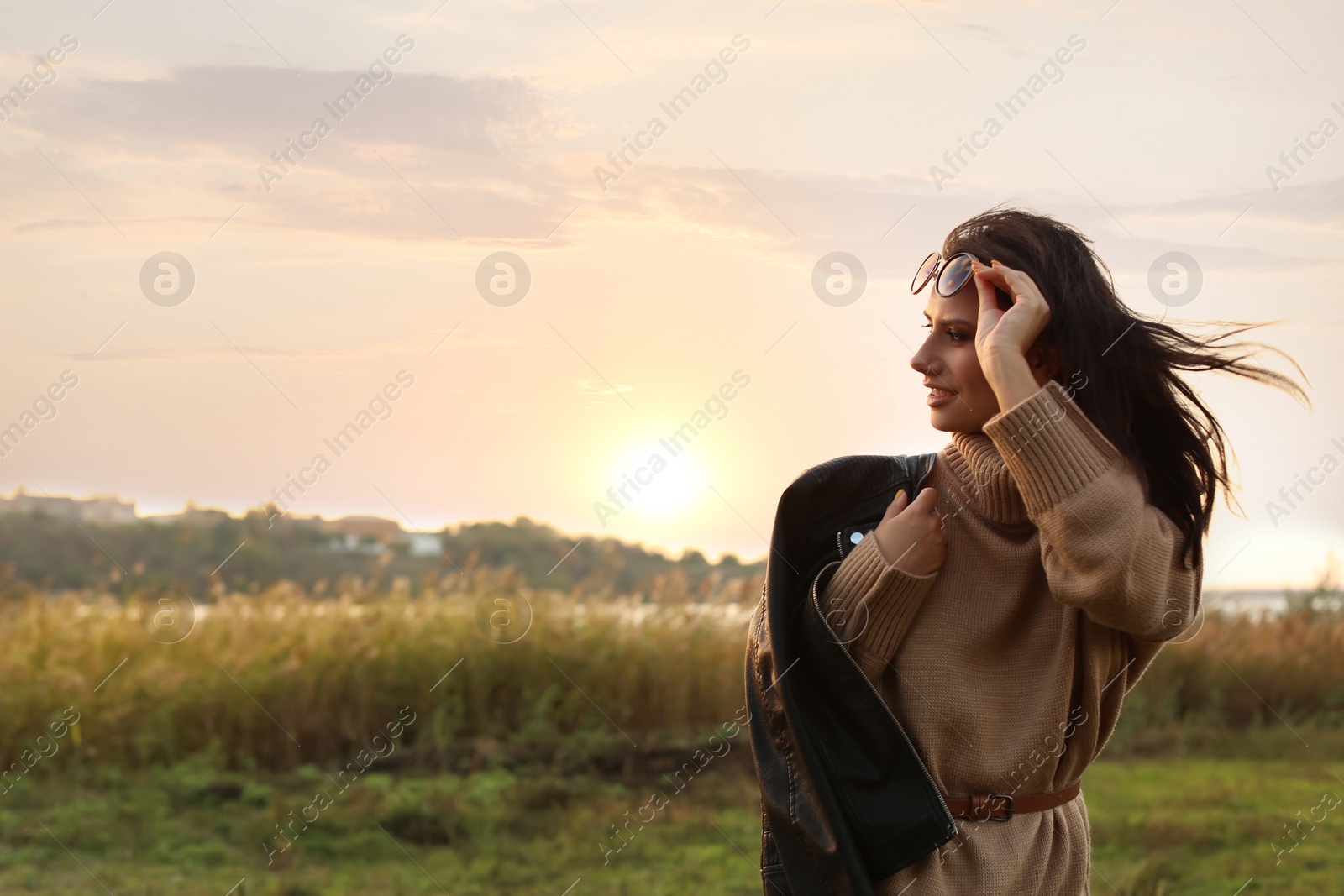 Photo of Beautiful young woman wearing stylish autumn clothes outdoors